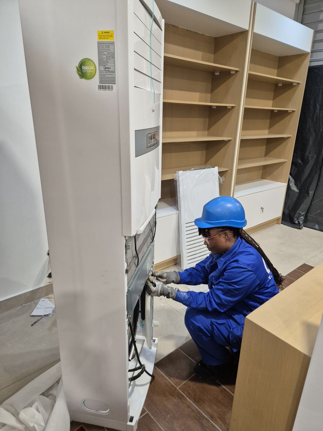 Technicienne CMS installant un climatiseur armoire