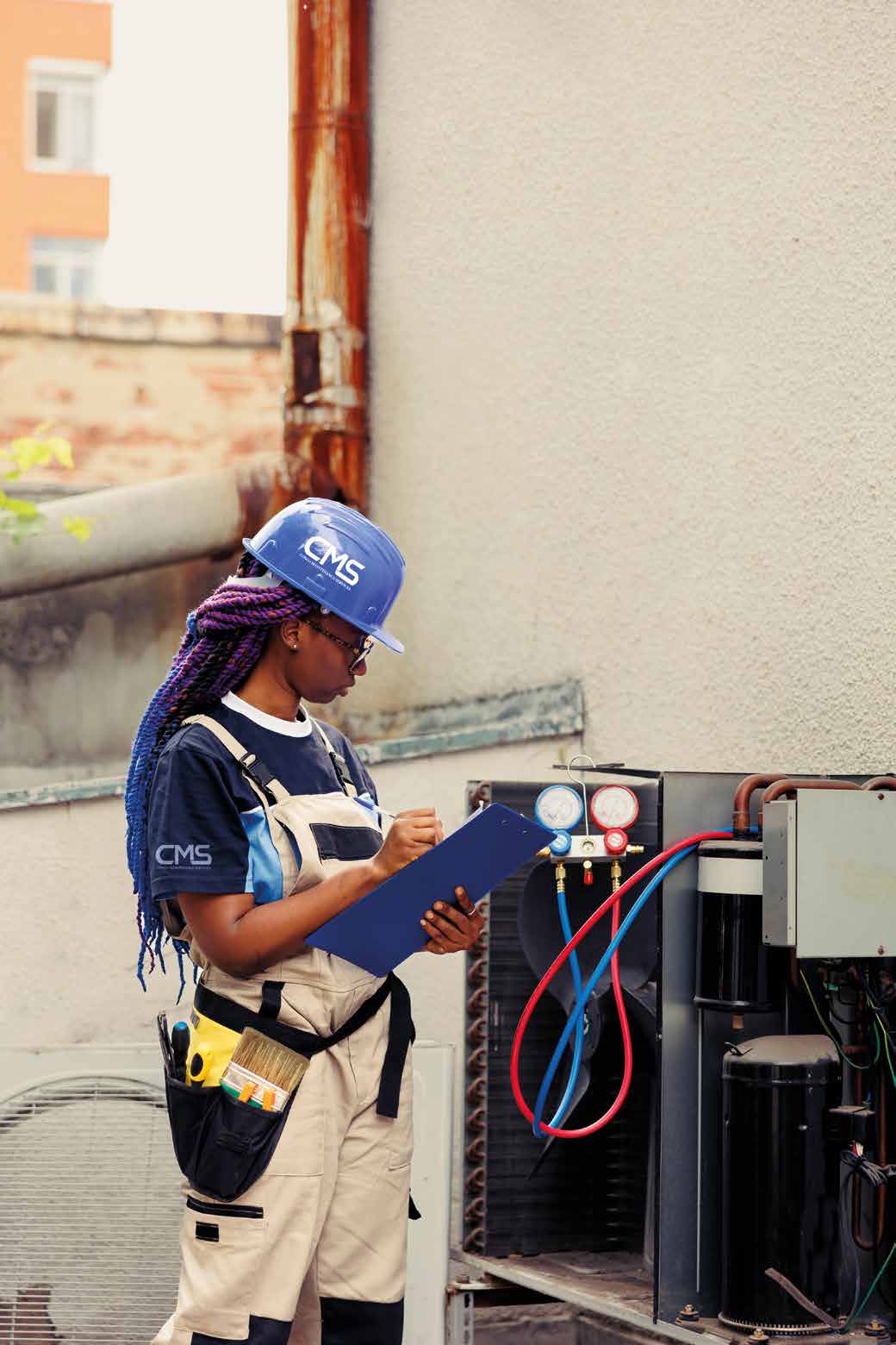 Technicienne CMS en intervention sur une unité de climatisation
